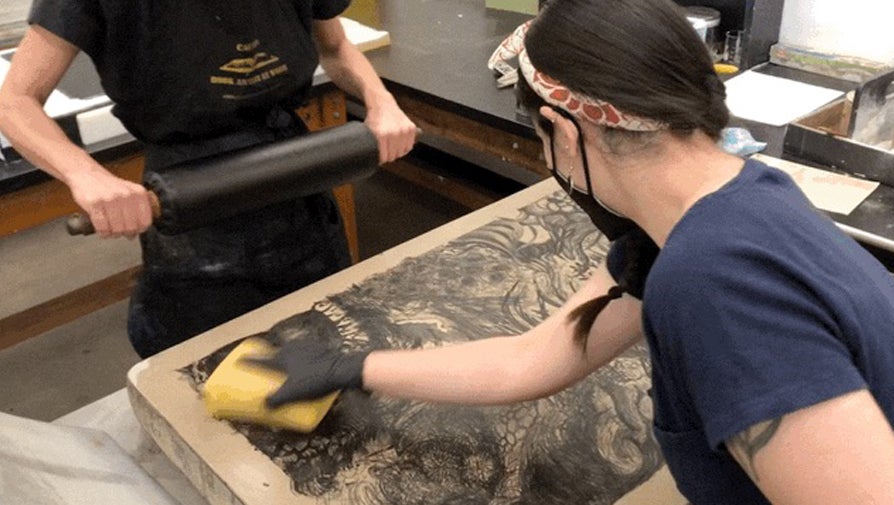 student inking linoprints